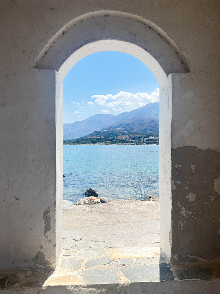 The view through the openning of the small white chapel of Georgiuopoli, Crete 